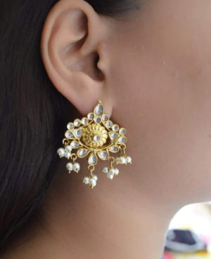 The carefully constructed stud earrings with valuable stones and pearls are made by arranging several stones surrounded by pearls and hanging beads.